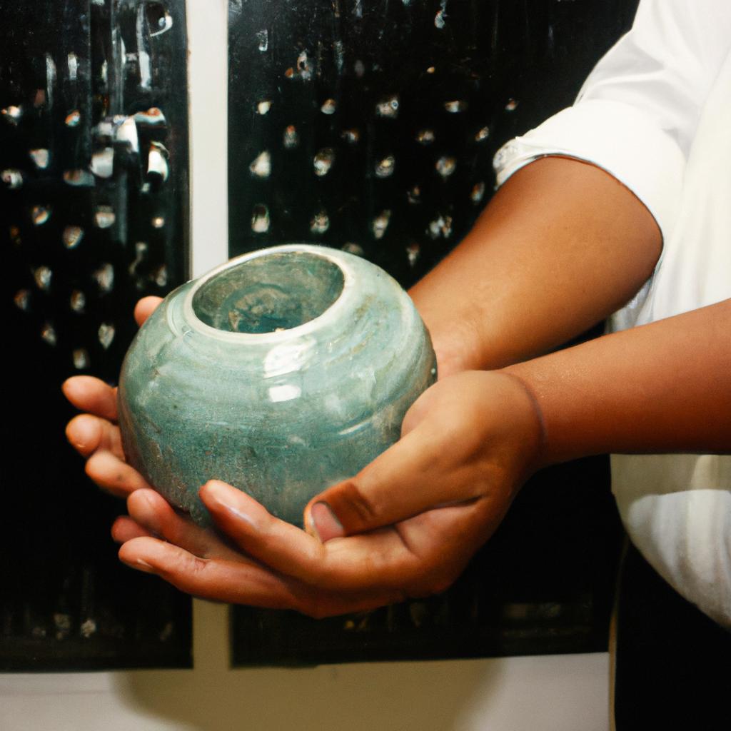 Person handling ceramic artwork respectfully