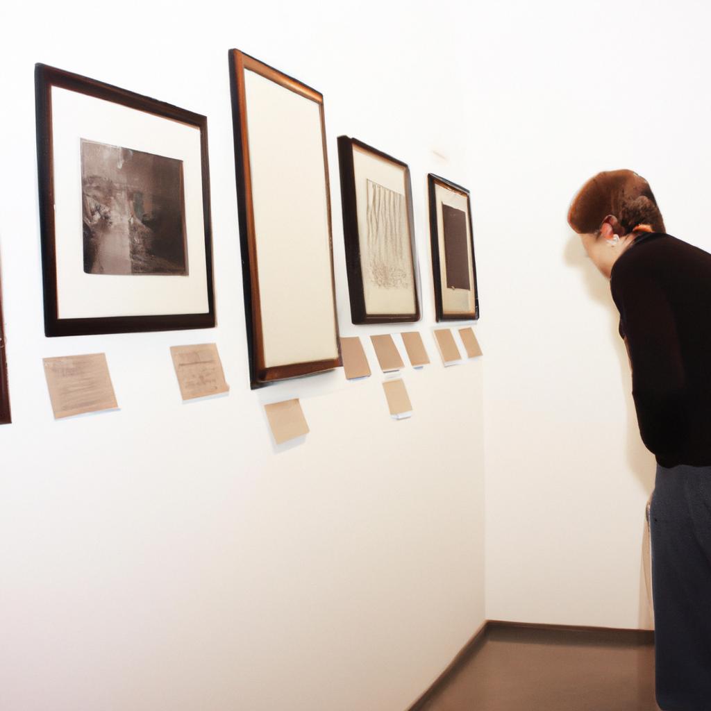 Person examining artwork in gallery